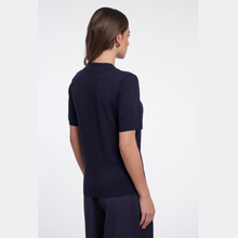 Load image into Gallery viewer, A woman shown from the back wearing a dark navy short-sleeve knit top and matching dark trousers against a plain light gray studio background.