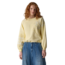 Load image into Gallery viewer, Woman wearing a light yellow sweater with lace details and blue jeans on a white background