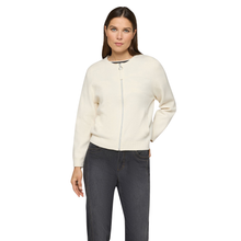 Load image into Gallery viewer, Woman wearing a cream-colored sweater and dark jeans on a white background