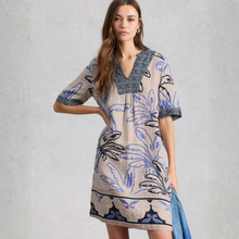 Load image into Gallery viewer, Woman wearing a patterned dress with a plain background
