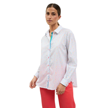 Load image into Gallery viewer, Woman wearing a white patterned shirt with a colorful zipper and red pants on a white background
