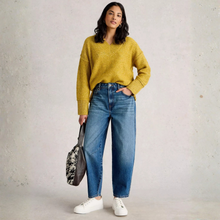 Load image into Gallery viewer, Woman wearing a yellow sweater, blue jeans, and white sneakers holding a patterned bag against a plain background