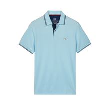 Load image into Gallery viewer, Light blue polo shirt with brand logo on a white background