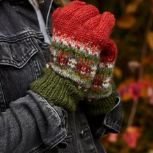 Load image into Gallery viewer, A close-up of a person wearing a pair of hand-knit winter gloves. The gloves feature a red cuff, a green ribbed wrist section, and a central patterned band with red, green, white, and gray yarn in a Fair Isle style.