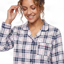 Load image into Gallery viewer, A woman wearing a long-sleeve plaid pajama shirt with a white, navy, and pink checkered pattern, shown against a plain white background.