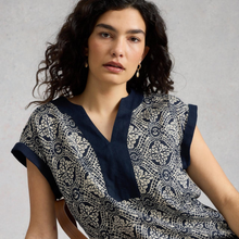 Load image into Gallery viewer, Woman wearing a navy and white patterned dress against a gray background