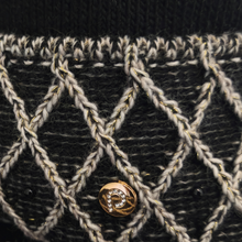 Load image into Gallery viewer, Close-up of a knitted garment or textile detail in white and black, featuring a braided cable pattern and a round metallic button with a crystal center.