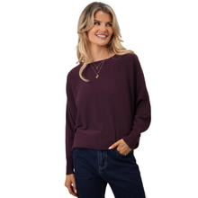 Load image into Gallery viewer, Woman wearing a dark purple sweater and blue jeans on a white background