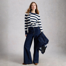 Load image into Gallery viewer, Woman wearing a striped sweater and blue jeans against a plain background