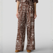 Load image into Gallery viewer, Person wearing a brown and white patterned outfit on a plain background