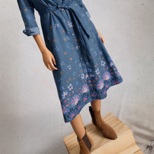 Load image into Gallery viewer, Mannequin wearing a blue floral dress with brown boots on a wooden block against a gray background