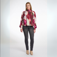 Load image into Gallery viewer, Woman wearing a colorful blouse and black pants on a white background