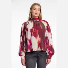 Load image into Gallery viewer, Woman wearing a colorful blouse with a white background