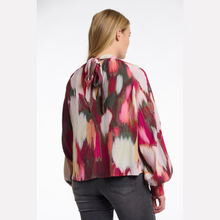 Load image into Gallery viewer, Woman wearing a colorful floral blouse on a white background