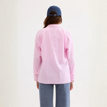Load image into Gallery viewer, Person wearing a pink striped shirt and blue jeans with a blue cap on a white background