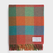 Load image into Gallery viewer, A folded plaid throw blanket with multicolor checkered squares in green, orange, blue, and rust tones, finished with fringe along one edge and a white Foxford label near the bottom.