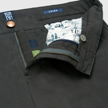 Load image into Gallery viewer, Close-up of dark charcoal gray chino pants showing the inner waistband, button closure, patterned lining, and interior labels including a blue 'CHINO' tag and a green 'M' patch.