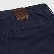 Load image into Gallery viewer, Navy blue pants with a brown label on a light gray background