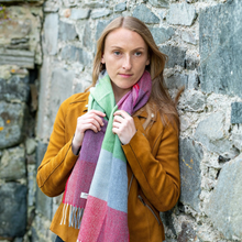 Load image into Gallery viewer, Woman wearing a colorful scarf against a stone wall
