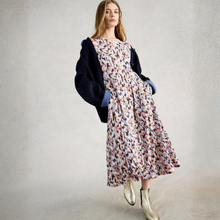 Load image into Gallery viewer, Woman wearing a floral dress with a black coat against a plain background