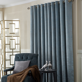 Eyelet curtains on pole in room setting 