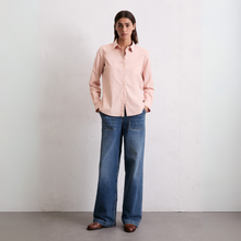 Load image into Gallery viewer, Woman wearing a light pink shirt and blue jeans against a plain background