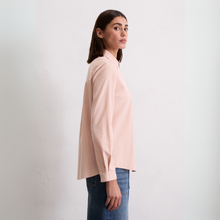 Load image into Gallery viewer, Woman wearing a light pink shirt and blue jeans against a white background