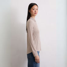 Load image into Gallery viewer, Woman wearing a patterned shirt and jeans against a plain background