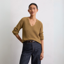 Load image into Gallery viewer, Person wearing a mustard yellow sweater and dark blue jeans against a plain background