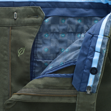 Load image into Gallery viewer, Close-up of a green jacket with blue quilted lining and a leaf emblem.