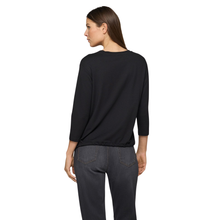 Load image into Gallery viewer, Woman wearing a black sweater and dark jeans on a white background