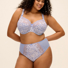 Load image into Gallery viewer, A woman modeling a light blue and white floral lace bra and matching high-waisted briefs against a plain beige background.