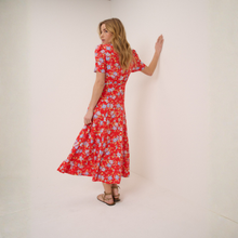 Load image into Gallery viewer, Woman wearing a red floral dress against a white background