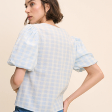 Load image into Gallery viewer, Woman wearing a light blue checkered top against a beige background