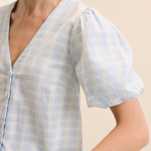 Load image into Gallery viewer, Light blue patterned blouse with short sleeves on a neutral background