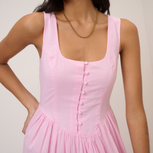 Load image into Gallery viewer, Pink dress with button details worn by a person on a plain background