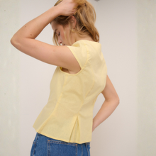 Load image into Gallery viewer, Woman wearing a yellow top and blue jeans against a plain background