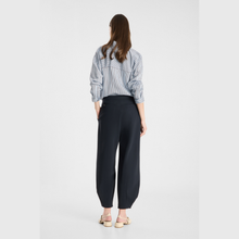 Load image into Gallery viewer, A woman is shown from behind wearing a blue and white vertically striped button-down shirt and dark navy wide-leg trousers, paired with beige flat sandals, against a light gray studio background.