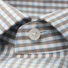 Load image into Gallery viewer, Close-up of a plaid shirt with a button, showing brown, blue, and white colors.