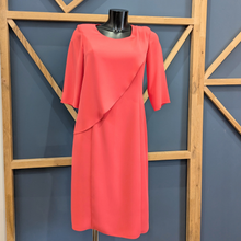 Load image into Gallery viewer, Coral dress on a mannequin against a geometric wooden and blue wall background