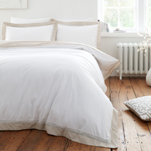 Load image into Gallery viewer, White bedding set on a bed in a room with wooden flooring and a radiator.