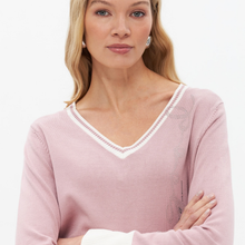 Load image into Gallery viewer, A woman wearing a light pink long-sleeve V-neck sweater with white trim along the neckline and white ribbed cuffs, photographed against a clean white background.