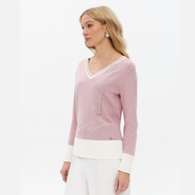 Load image into Gallery viewer, A woman wearing a dusty pink long-sleeve knit sweater with white contrast trim at the V-neck, cuffs, and hem, paired with white trousers, photographed against a clean white studio background.