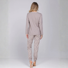 Load image into Gallery viewer, A woman shown from the back wearing a two-piece pajama set consisting of a solid heathered taupe long-sleeve top and matching patterned pants with a light taupe leaf print, set against a plain light gray studio background.