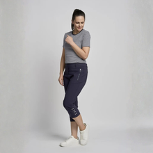 Load image into Gallery viewer, Woman wearing a striped shirt and navy capri pants on a plain background