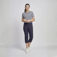 Load image into Gallery viewer, Woman wearing a striped shirt and navy capri pants on a white background