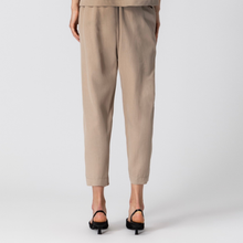 Load image into Gallery viewer, Beige pants worn by a person on a white background