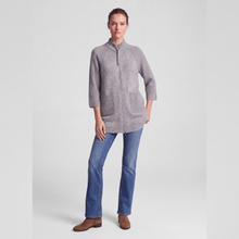 Load image into Gallery viewer, A woman modeling a light gray zip-up jacket with a mock neck and front pockets, paired with blue jeans and brown boots, against a light gray studio background.