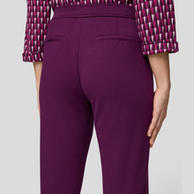 Load image into Gallery viewer, Purple pants worn by a person on a light gray background