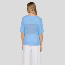 Load image into Gallery viewer, Woman wearing a light blue top with a geometric pattern on a plain background